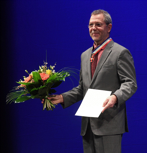 Christoph de Boor mit Landesverdienstorden, Ernennungsurkunde und Blumenstrauß