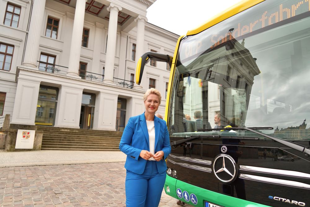 Ministerpräsidentin Manuela Schwesig steht lächelnd vor einem E-Bus der Verkehrsgesellschaft Ludwigslust-Parchim