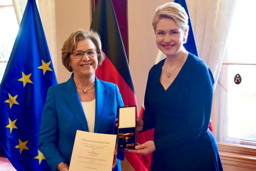 Ministerpräsidentin Manuela Schwesig mit Dr. Sigrid Maria Biffar, die ihre Verleihungsurkunde in den Händen hält. Die Ministerpräsidentin hält das aufgeklappte Etui mit dem Bundesverdienstorden in die Kamera.