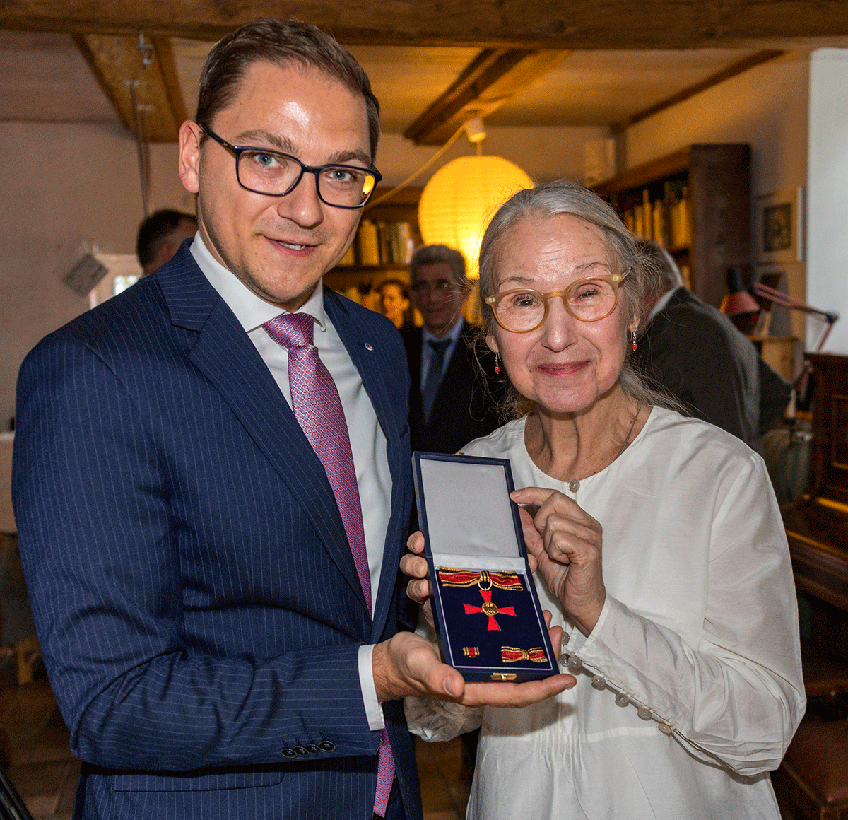 Patrick Dahlemann und Katrin Eigenfeld halten das Verdienstkreuz am Bande des Bundesrepublik Deutschland, eine Auszeichnung im Namen des Bundespräsidenten, in die Kamera