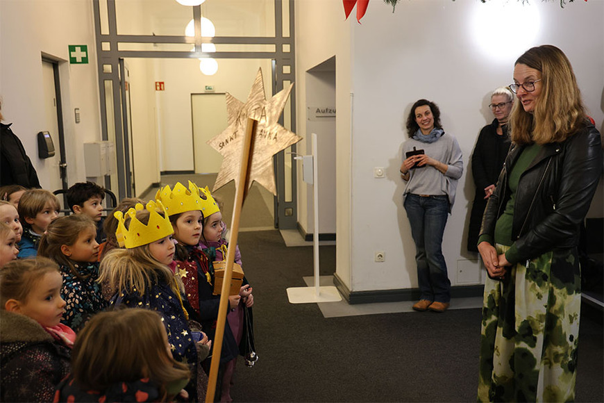 Ministerin Bettina Martin begrüßt die Sternsinger der Schweriner Kita St. Anna im Foyer des Ministeriums. 
