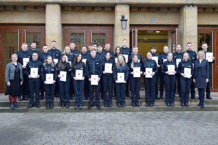 Justizstaatssekretärin Babette Bohlen (links), stellvertretende Leiterin der Abteilung Justizvollzug im Ministerium Gloria Arndt mit der AVD-Klasse mit den neu ernannten Anwärterinnen und Anwärtern sowie den erfolgreichen Absolventinnen und Absolventen. @JM