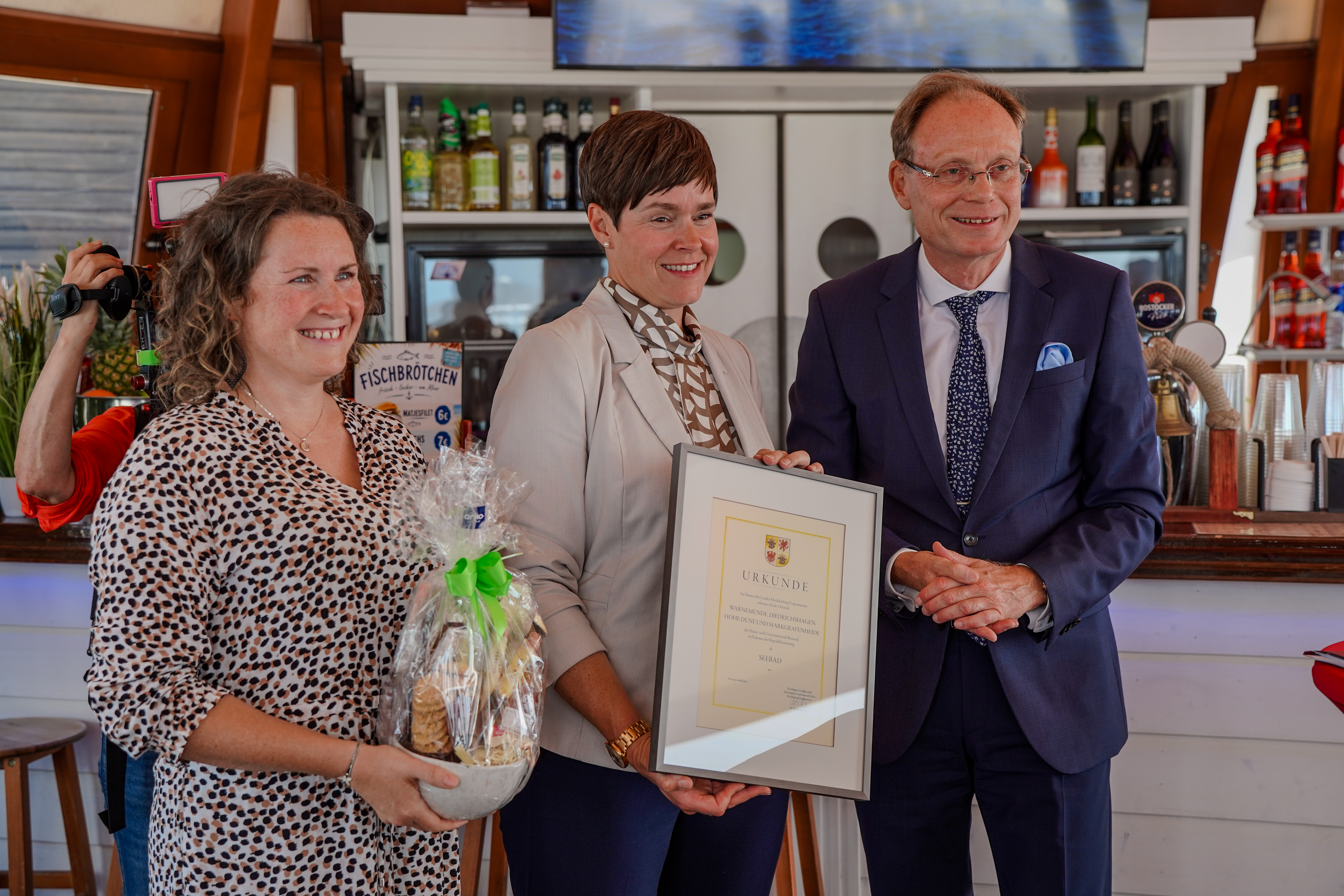 Staatssekretär Jochen Schulte (r.) überreicht Auszeichnungen an Rostocker Seebäder (© WM)