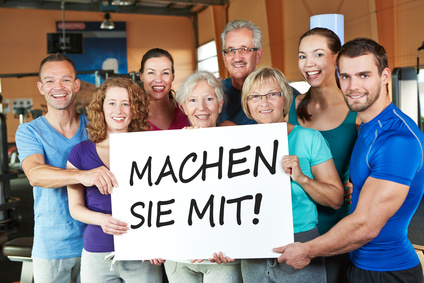 Gruppe hät Schild mit dem Slogan: Machen Sie mit!, in der Hand 