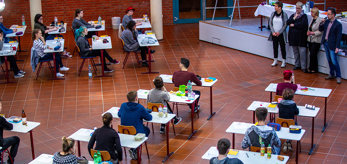 Schülerinnen und Schüler schreiben in der Schulaula eine Abschlussklausur, Foto: Jens Büttner