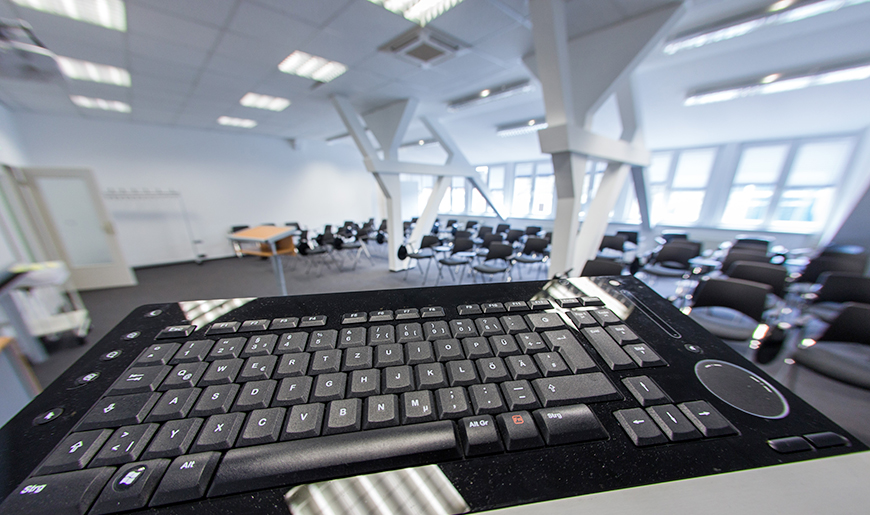 Tagungsraum mit Dachschräge im IQ M-V. Im Vordergrund ein Rednerpult, auf dem eine Computertastatur liegt. Tagungsraum mit Dachschräge im IQ M-V. Im Vordergrund ein Rednerpult, auf dem eine Computertastatur liegt.