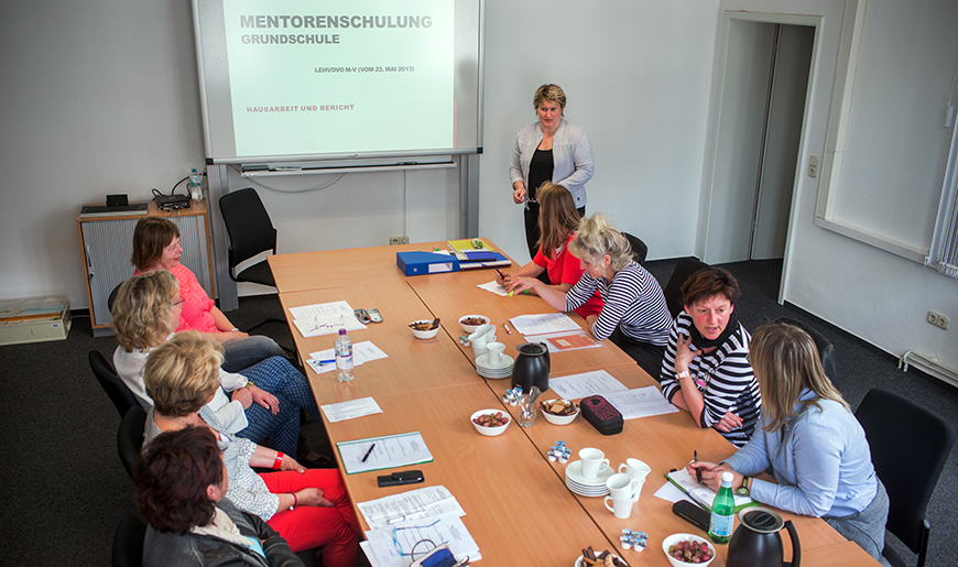 Fortbildungsteilnehmerinnen sitzen an einem Tisch in einem Raum. Fortbildungsteilnehmerinnen sitzen an einem Tisch in einem Raum.