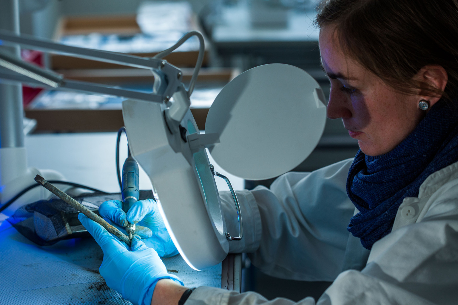 Restauratorin Anica Kelp legt vorsichtig die Oberfläche des rund 1000 Jahre alten Hakens frei, Foto: Jens Büttner