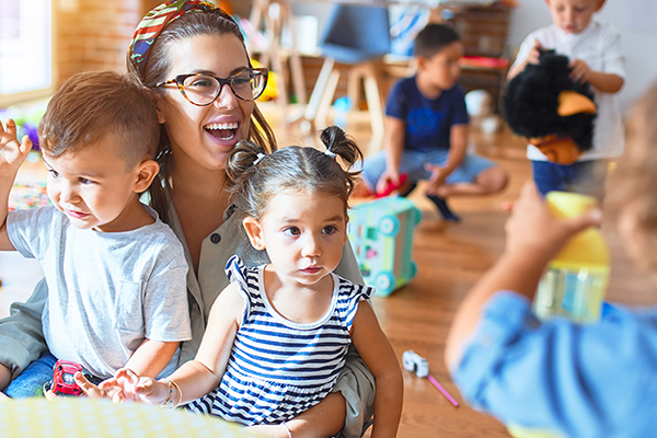 Eine junge Erzieherin spielt mit Kindern, Foto: Krakenimages.com/Shutterstock