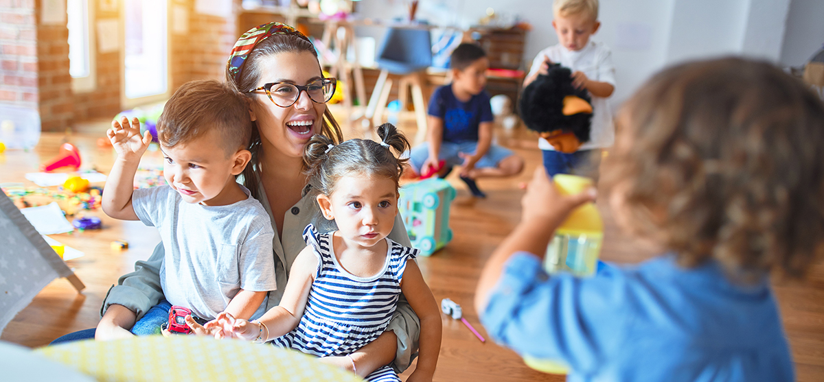 Eine junge Erzeiherin spielt mit Kindern, Foto: Krakenimages.com/Shutterstock