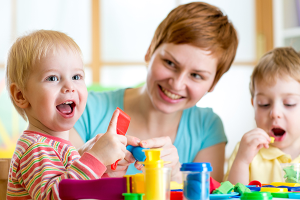 Eine Kindertagesfachkraft spielt mit Kindern in der Kita, Foto: shutterstock.de