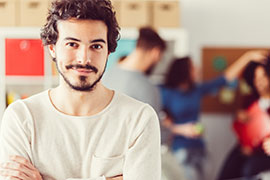 Junger Lehrer in Großaufnahme, die Arme vor der Brust verschränkt. Foto: istock.com/martin-dm