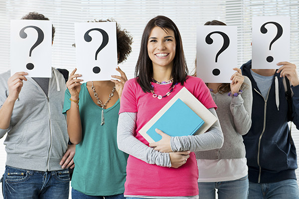 Fünf Jugendliche stehen frontal zur Kamera. Vier von ihnen halten sich ein weißes Blatt mit einem Fragezeichen vor den Kopf. Foto: panthermedia