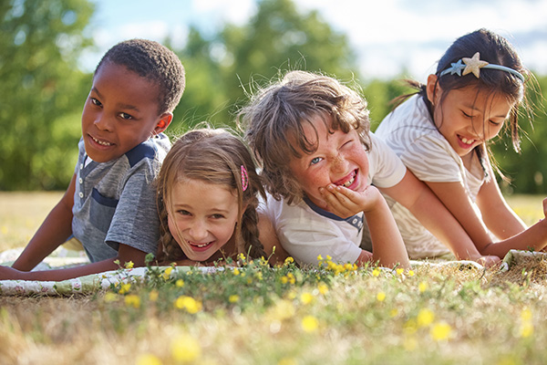 Mehrere kinder liegen auf einer Wiese, Foto:shutterstock/Robert_Keschke