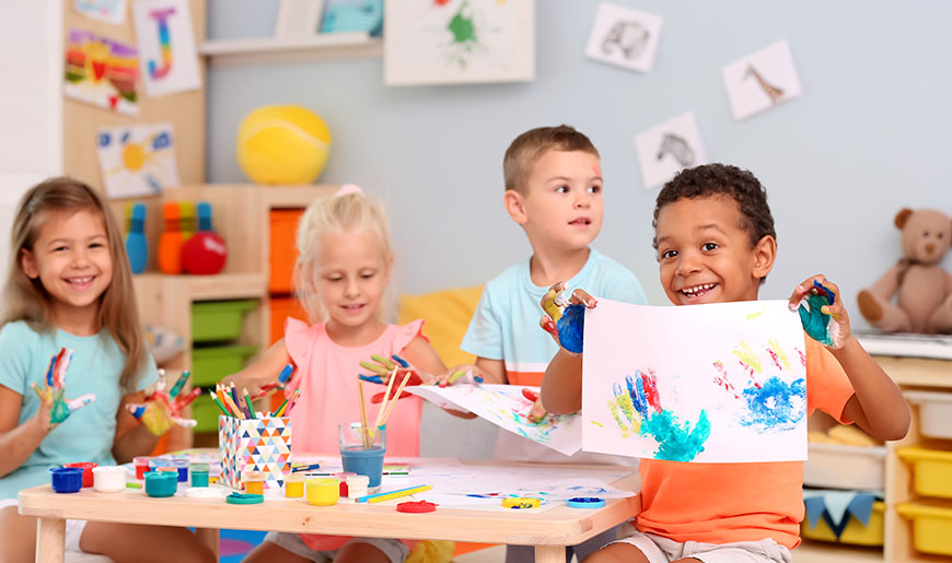 Kinder bemalen ihre Hände mit Fingerfarbe und stempeln sie auf Papier, Foto: Africa Studio/Shutterstock