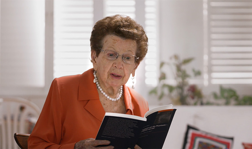 Die Zeitzeugin Bathsheva Dagan liest aus einem Buch vor.