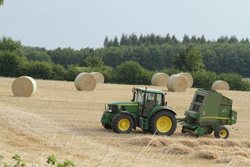 Traktor bei der Ernte mit Heuballen