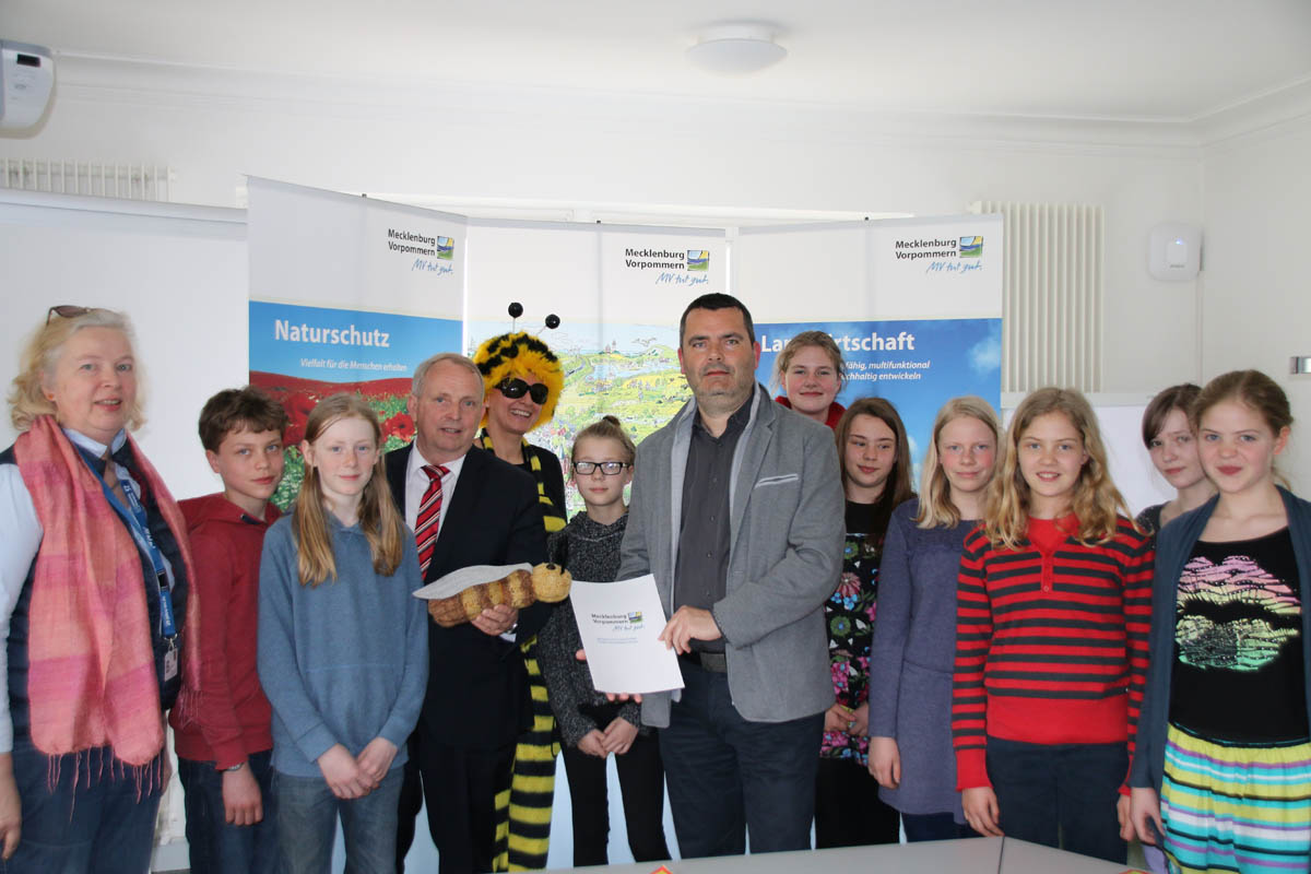 Unterzeichnung der Vereinbarung zum Bienenlehrpfad für das Schuljahr 2015/2016 (v.l.n.r. Kinder der AG „Junge Naturforscher“, AG-Leiterin Ebel, Minister Dr. Backhaus, „Biene“ Antje, Schulleiter Vorfahr)