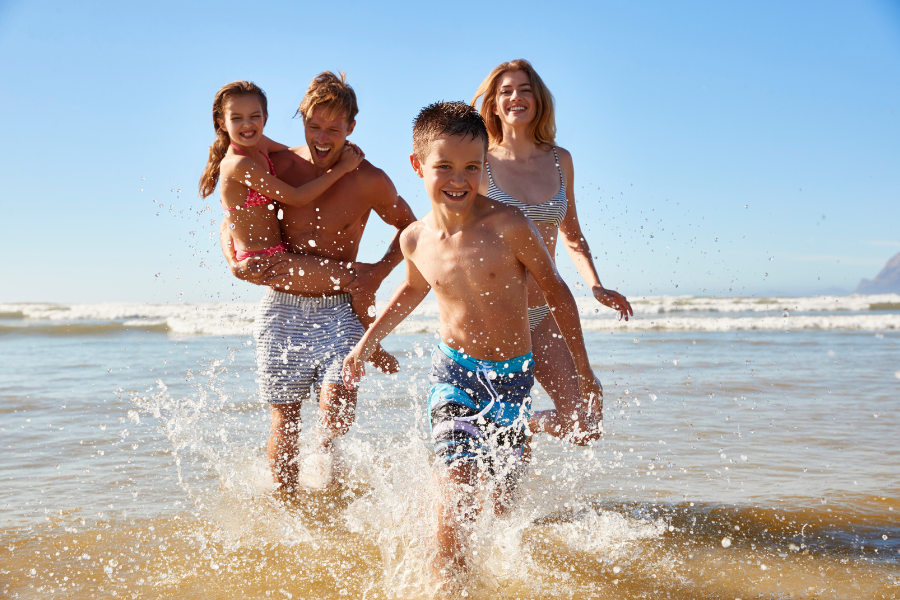 Eine Famile kommt aus dem Wasser gelaufen 