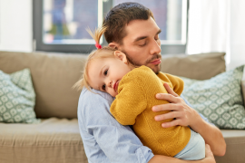 Mann hält Kleinkind auf dem Arm