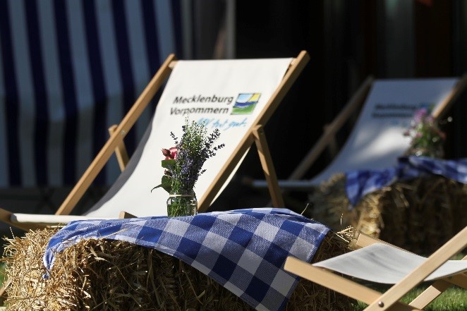 Perfekter Landurlaub: Klappstühle neben Heuballen mit Tischdecken