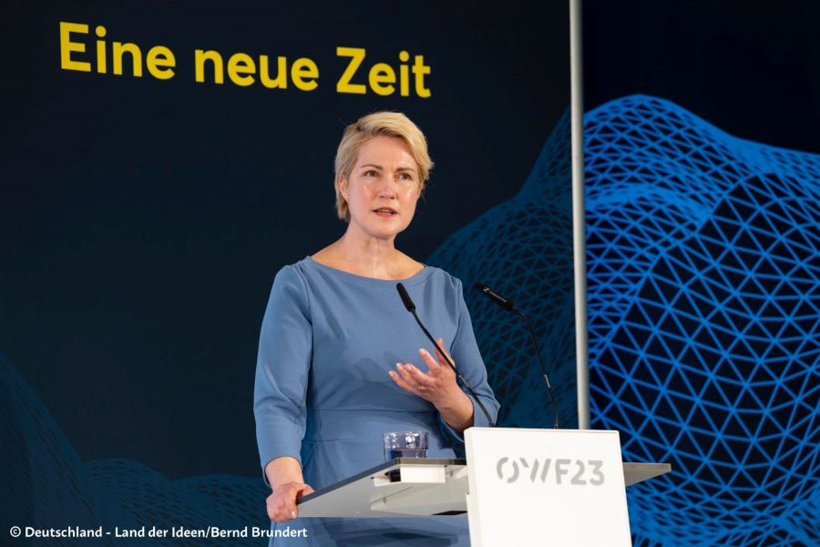 Ministerpräsidentin Manuela Schwesig mit einer Geste am Rednerpult. Hinter ihr steht die Aufschrift "Eine neue Zeit" neben einer grafischen Gestaltung.