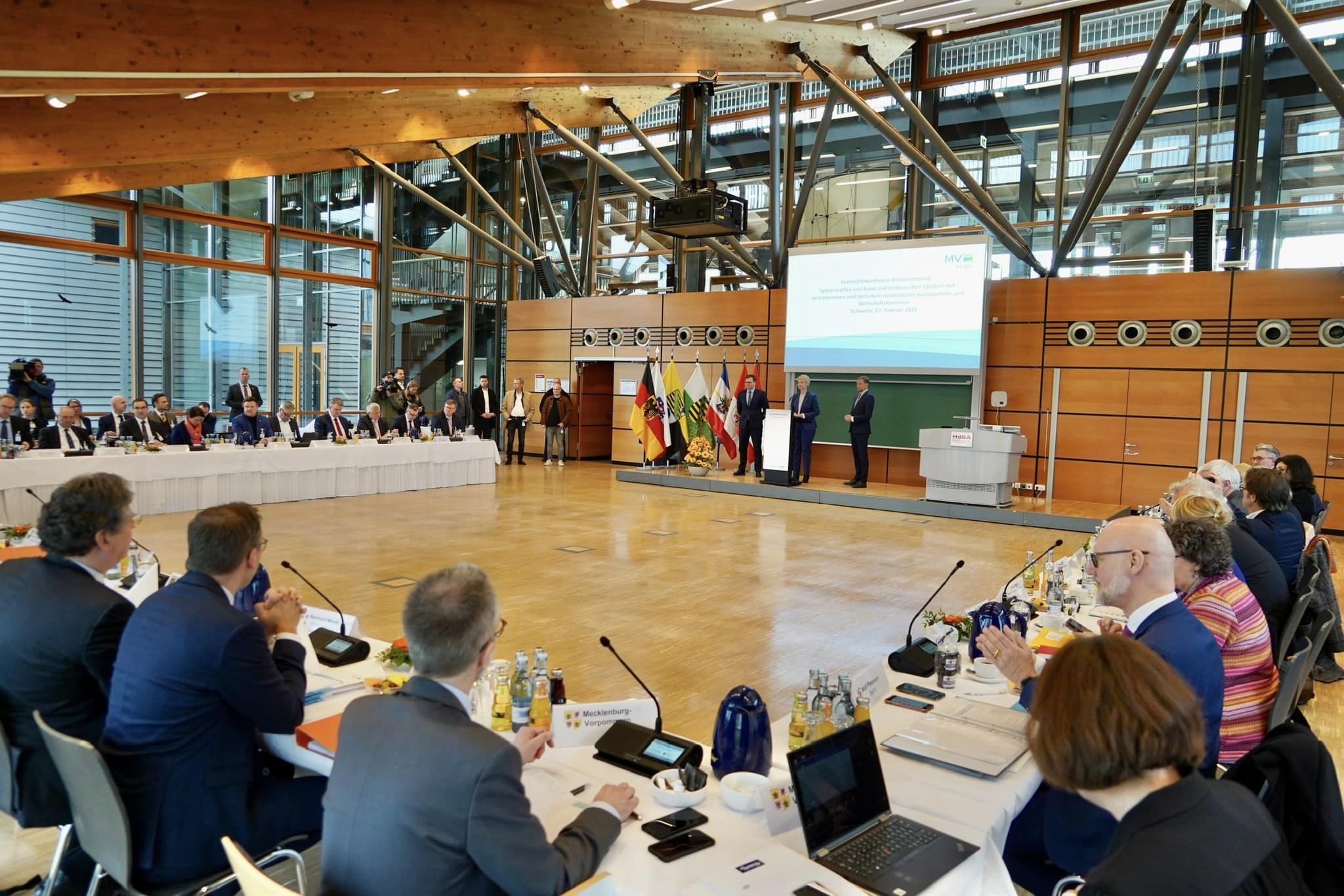 Blick in den Tagungssaal der Hochschule der Bundesagentur für Arbeit. Zu sehen sind die zu drei Seiten angeordneten Tischreihen der Teilnehmerinnen und Teilnehmer mit dem Podium an der Stirnseite.