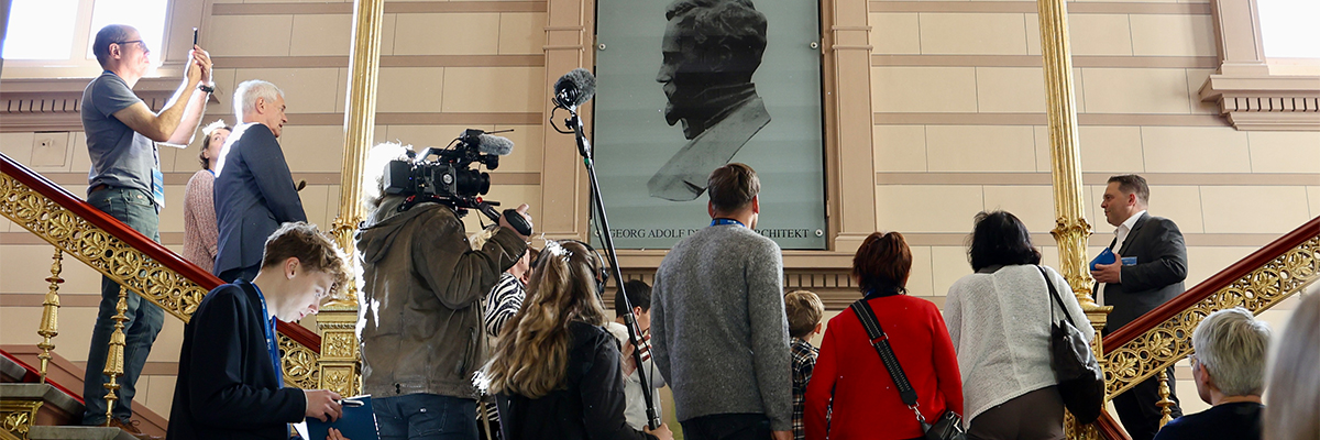 Besuchergruppe bei einer Führung im Treppenhaus der Staatskanzlei mit Medienbegleitung