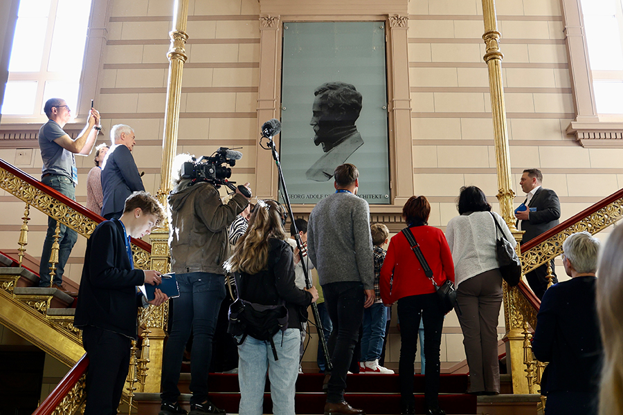 Besuchergruppe bei einer Führung im Treppenhaus der Staatskanzlei mit Medienbegleitung