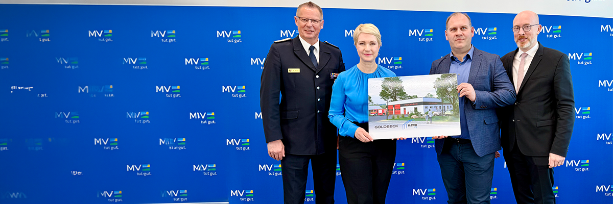 Landesbrandmeister Hannes Möller, Ministerpräsidentin Manuela Schwesig, Wotan Drescher, Geschäftsführer von KAWO Ing, der Minister für Inneres und Bau Christian Pegel. Schwesig und Drescher halten eine Abbildung des Musterfeuerwehrhauses hoch.