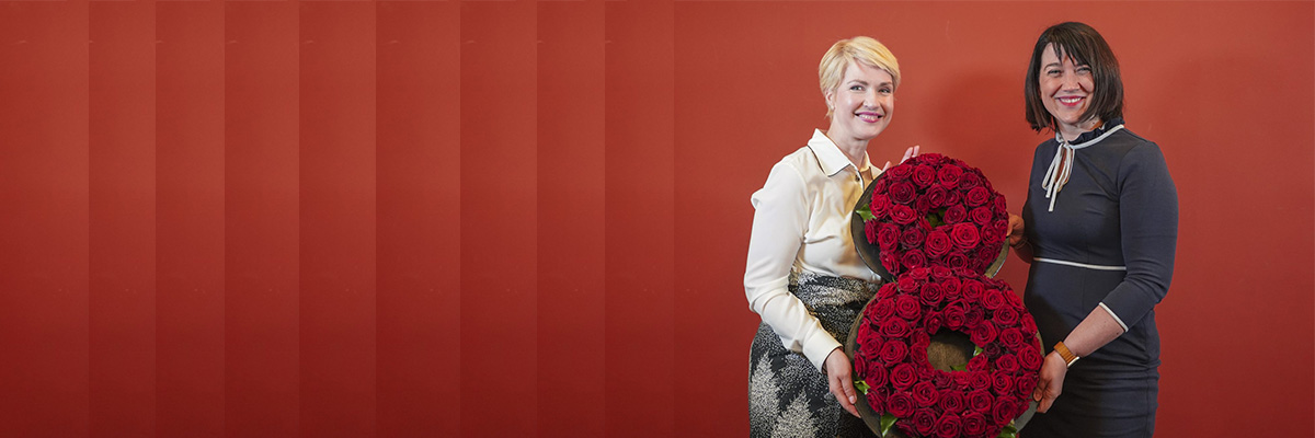 Ministerpräsidentin Schwesig und Gleichstellungsministerin Bernhardt mit einer blumengeschmückten "8", die für den 8. März steht.