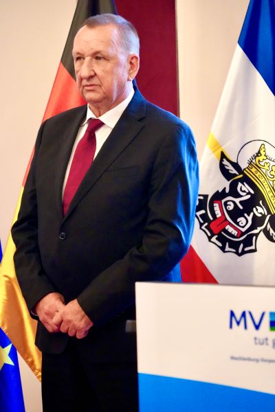 Gerold Jürgens. Im Hintergrund ist die Deutschland- und die Mecklenburg-Vorpommern-Flagge zu erkennen.
