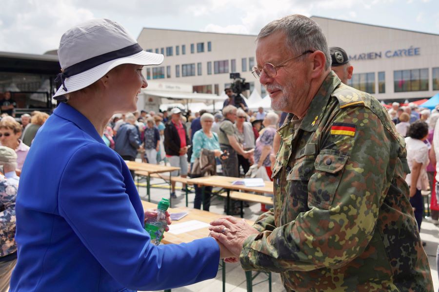 Die Ministerpräsidentin mit Sommerhut im Gespräch mit Brigadegeneral Uwe Nerger, der ihre Hand schüttelt