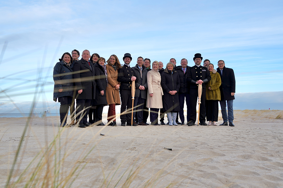 Das Kabinett und seine Gäste mit Glücksbringern am Strand von Warnemünde