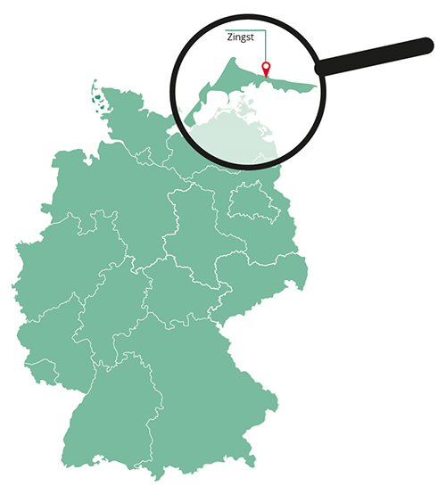 Die Abbildung zeigt eine grüne Deutschlandkarte. Am oberen rechten Rand von der Karte ist eine schwarze Lupe eingezeichnet. Sie zeigt vergrößert die Fläche von dem Gebiet "Fischland-Darß".