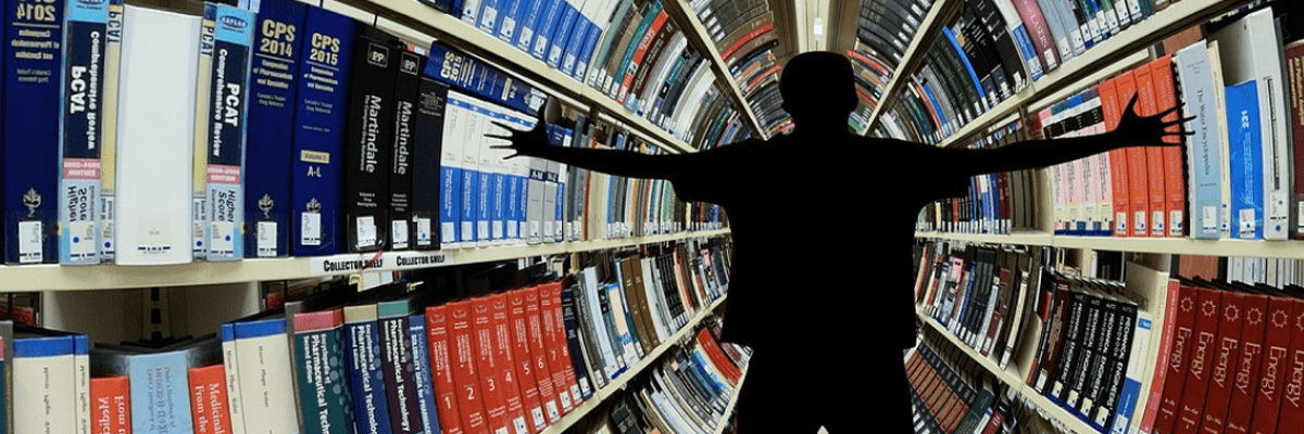 Mann breitet die Arme vor einer großen Bücherwand aus 