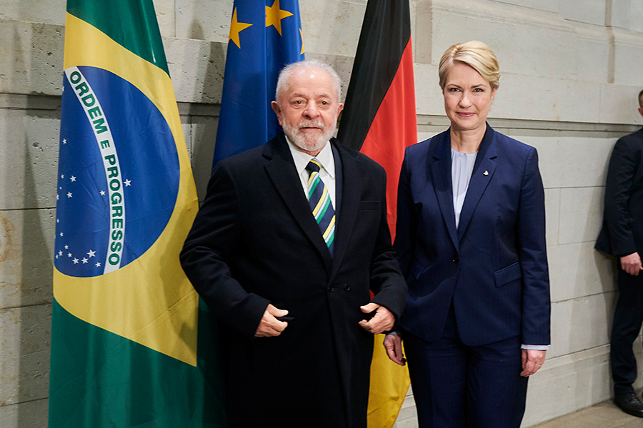 Die Präsidentin des Bundesrates und Brasiliens Präsident stehen vor den Flaggen Brasiliens, der Europäischen Union und Deutschlands.