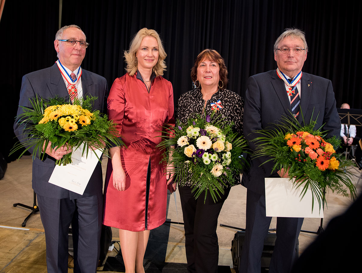 Gruppenfoto von Ministerpräsidentin Manuela Schwesig mit Rainer Tschirner (links), Brigitte Thielk und Hans-Joachim Grätsch. Die drei Ausgezeichneten halten ihre Ernennungsurkunden und Blumensträuße in den Händen. © Staatskanzlei Gruppenfoto von Ministerpräsidentin Manuela Schwesig mit Rainer Tschirner (links), Brigitte Thielk und Hans-Joachim Grätsch. Die drei Ausgezeichneten halten ihre Ernennungsurkunden und Blumensträuße in den Händen.