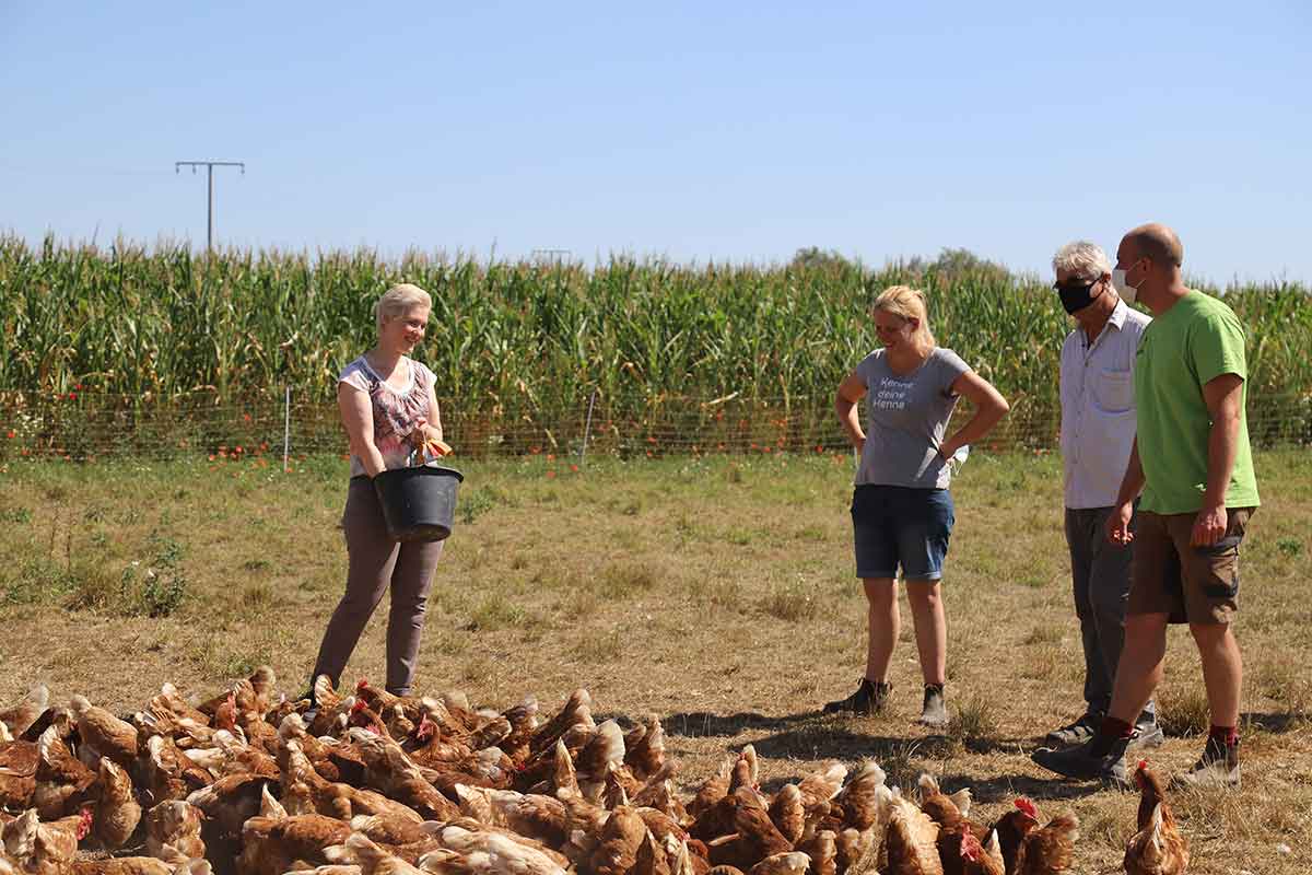 Ministerpräsidentin Manuela Schwesig füttert Hühner und ist im Gespräch mit Anna und Lukas Propp sowie Bauernrpräsident Detlef Kurreck