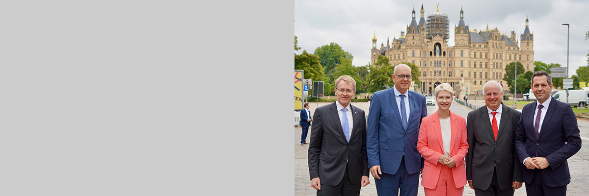 Gruppenbild von links nach rechts mit Ministerpräsident Daniel Günther (Schleswig-Holstein), Bürgermeister Dr. Andreas Bovenschulte (Hansestadt Bremen), Ministerpräsidentin Manuela Schwesig, Jan Pörksen (Chef der Senatskanzlei der Hansestadt Hamburg) sowie Ministerpräsident Olaf Lies (Niedersachsen). Im Hintergrund ist das Schweriner Schloss zu sehen.