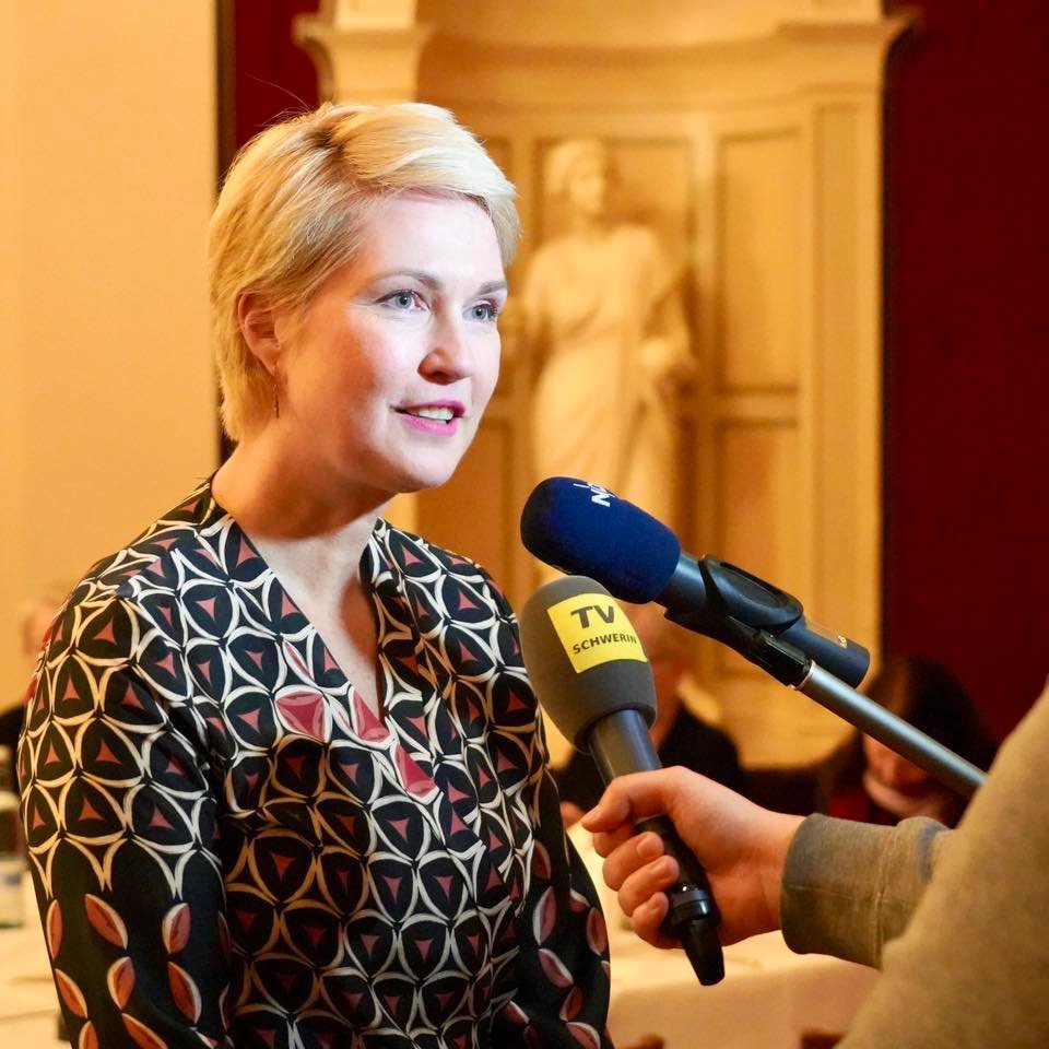 Ministerpräsidentin Manuela Schwesig bei einem Interview mit zwei Mikrophonen, in die sie spricht 