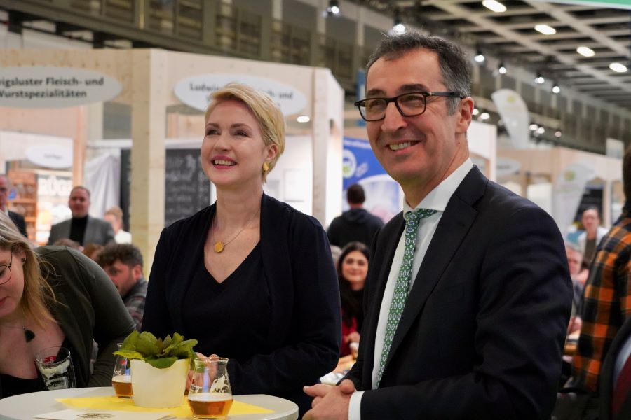 Ministerpräsidentin Manuela Schwesig mit Bundeslandwirtschaftsminister Cem Özdemir an einem Stehtisch. Beide lächeln und haben ein kleines Glas Bier vor sich stehen.