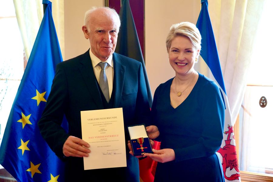 Ministerpräsidentin Manuela Schwesig mit Rainer Dopp. Beide halten den Bundesverdienstorden gemeinsam in dei Kamera. Rainer Dopp hält seine Urkunde hoch.