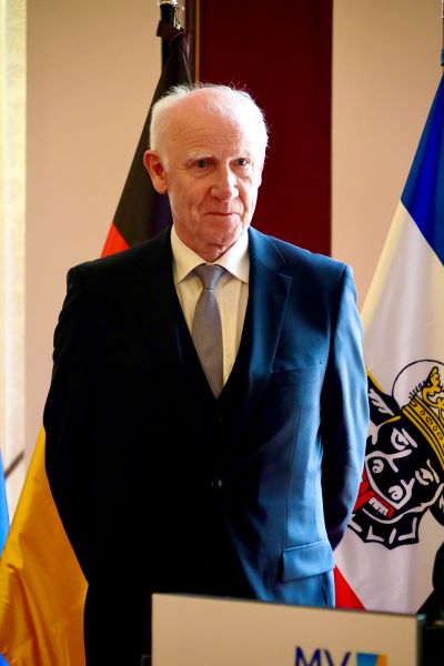 Rainer Dopp. Hinter ihm sind die Deutschland- und die MV-Flagge zu erkennen.