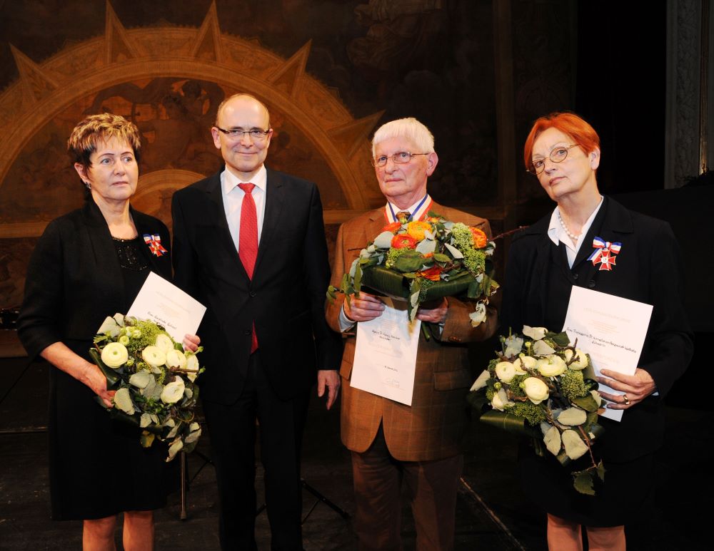 Der damalige Ministerpräsident Erwin Sellering mit Sieglinde Scheel, Dr. Heinz Henker sowie Prof. Dr. Katharina-Kornelia von Berswordt-Wallrabe. Die Geehrten halten Blumensträuße und ihre Urkunden in den Händen.