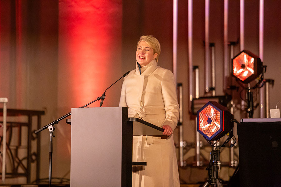 Die Ministerpräsidentin bei ihrer Ansprache zur Eröffnung des Jubiläumsjahres. Sie steht an einem Pult mit Mikrophon. Im Hintergrund sind zwei Scheinwerfer zu sehen.