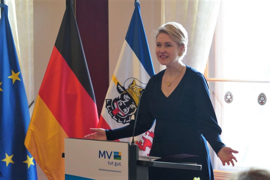 Ministerpräsidentin Manuela Schwesig am Rednerpult mit einer Geste. Hinter ihr sind die EU-, die Deutschland- und die Mecklenburg-Vorpommern-Flagge zu sehen.