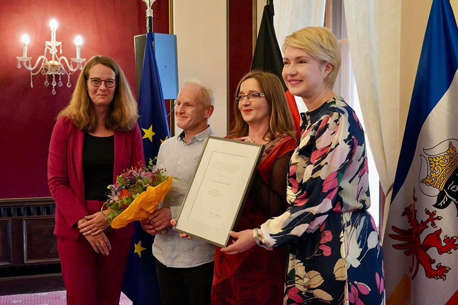 Ministerpräsidentin Manuela Schwesig und Ministerin Bettina Martin mit Mareike Scheil und Torsten Wiedemann vom Fritz-Reuter-Ensemble Anklam. Torsten Wiedemann hält einen Blumenstrauß, Mareike Scheil gemeinsam mit der Ministerpräsidentin die Urkunde.