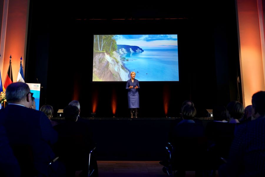 Ministerpräsidentin Manuela Schwesig bei ihrer Ansprache zum Neujahrsempfang auf der Bühne. Im Hintergrund ist ein Bild der Kreidefelsen von der Insel Rügen zu sehen.
