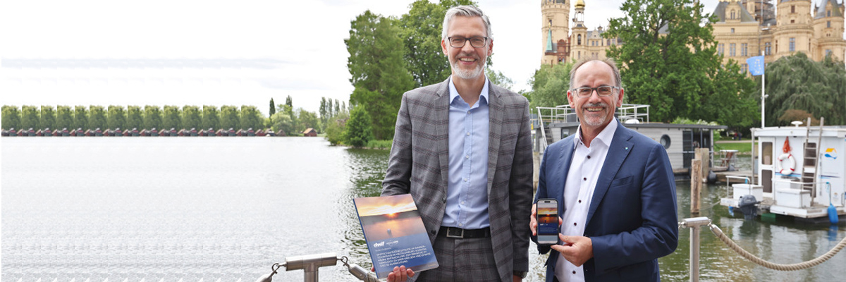 Wirtschaftsminister Dr. Wolfgang Blank mit dwif-Geschäftsführer Karsten Heinsohn am Schweriner See vor dem Hintergrund des Schweriner Schlosses.